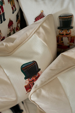 Several Nutcracker Stripe Pillows in Angora, featuring festive nutcracker designs, are arranged together, creating a cozy and charming holiday display.