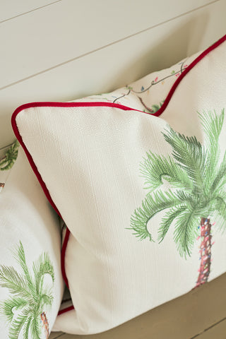 Two white Oversized Holiday Palmetto Pillows with green palm prints and red piping by Sewing Down South rest against a white shiplap wall, adding a crisp, coastal Christmas accent to your seasonal decor.
