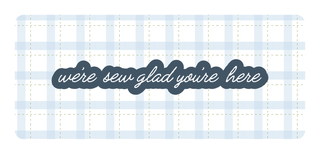 A blue and white plaid background with the phrase “were sew glad you’re here” in cursive, displayed in dark blue with a white outline.