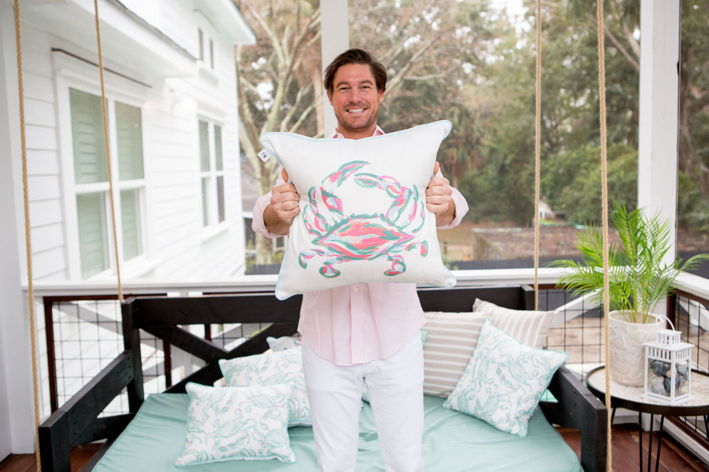 The Outdoor Coral King Crab Pillow features a vibrant abstract crab design in pink and teal on white, accented with blue piping. Made from durable SDS Shield® Outdoor Fabric, it reflects Sewing Down South™ design elegance, enhancing any exterior space.