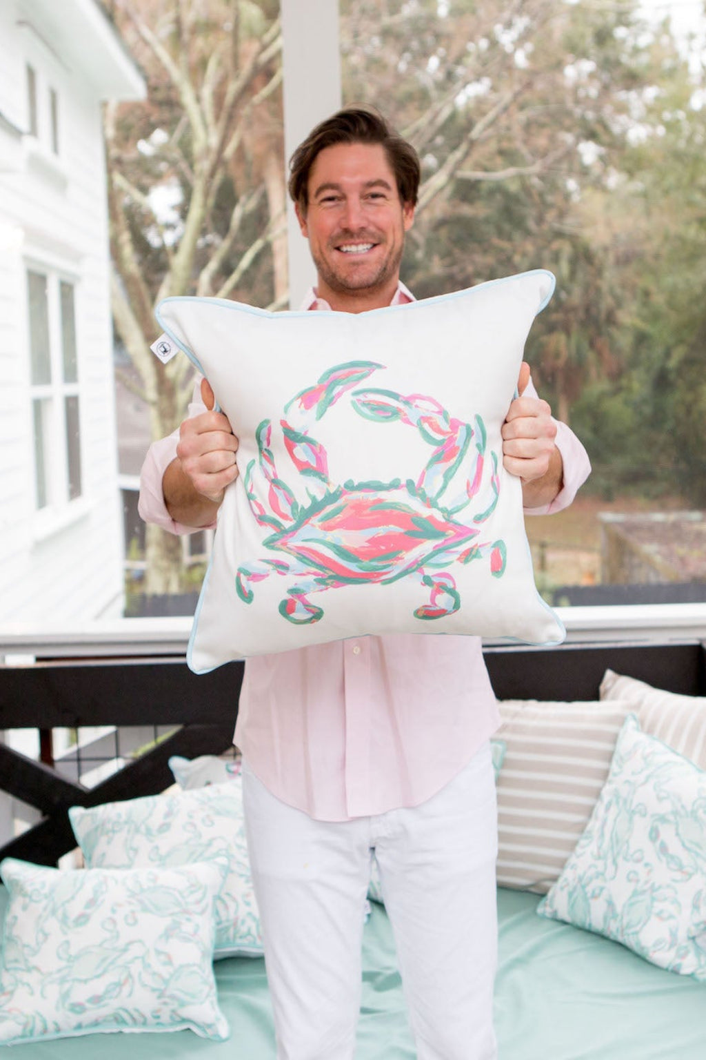 The Outdoor Coral King Crab Pillow features a vibrant abstract crab design in pink and teal on white, accented with blue piping. Made from durable SDS Shield® Outdoor Fabric, it reflects Sewing Down South™ design elegance, enhancing any exterior space.