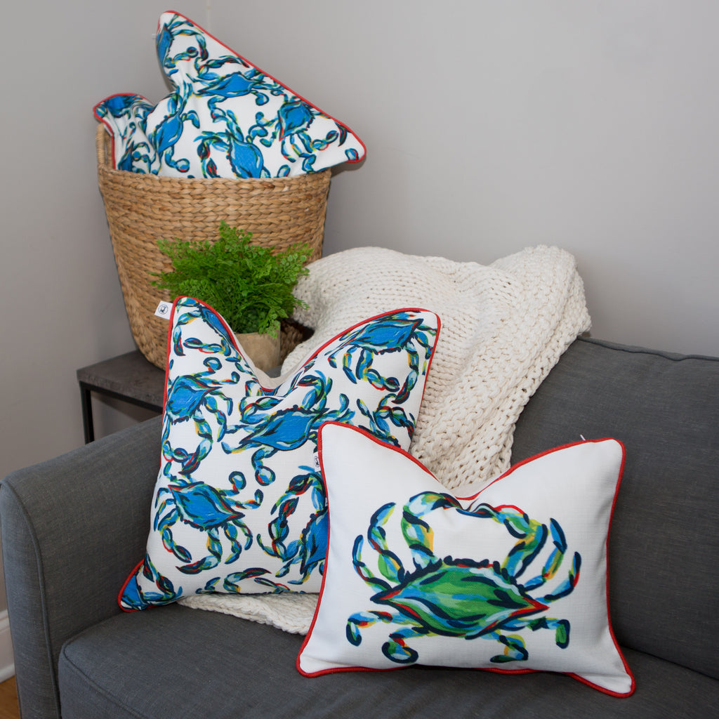 The Crab Craze, Shades of Blues Pillow features a lively crab print on white with red piping, embodying coastal flair. Blue crabs are dynamically arranged in various directions, designed by Sewing Down South.