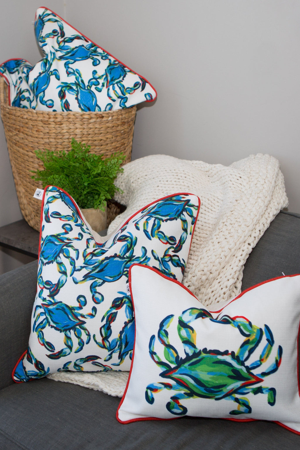 The Crab Craze, Shades of Blues Pillow features a lively crab print on white with red piping, embodying coastal flair. Blue crabs are dynamically arranged in various directions, designed by Sewing Down South.