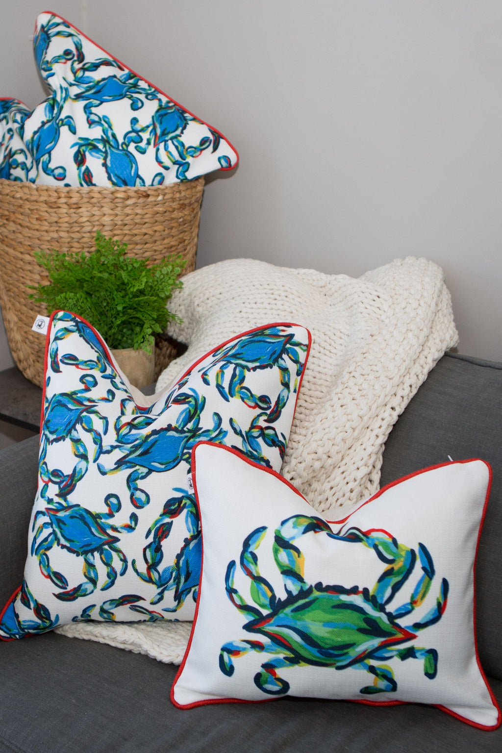 The King Crab Lumbar Pillow displays a vibrant King Crab print on a light pink background, with the crabs blue, green, and orange hues framed by a thin red outline, embodying Sewing Down Souths signature style.