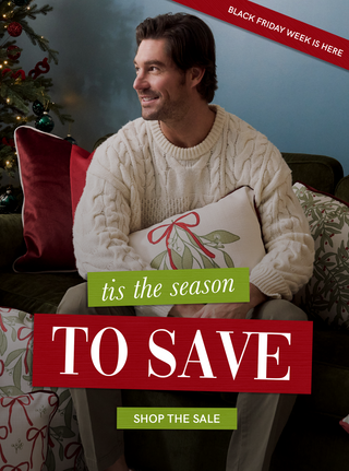 Man sitting on a couch with a Christmas tree, holding a gift, and promotional text overlay for Black Friday sale.