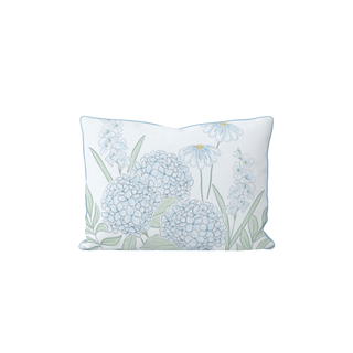 The Bouquet Lumbar Pillow is a rectangular white pillow with light blue hydrangeas, soft green leaves, and white daisies—an elegant accent to bring tropical decor into any room.