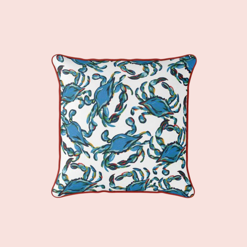 The Crab Craze, Shades of Blue Outdoor Pillow showcases a playful pattern of blue crabs with swirling accents on a light pink background. Decorated with red edging and made from SDS Shield® Outdoor Fabric, its ideal for adding coastal flair to indoor or outdoor spaces.