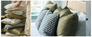 Stack of decorative pillows on a surface and arranged on a bed.