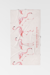The Flamingo Beach Towel is a light-colored cotton towel featuring pink flamingos and SEWING DOWN SOUTH CHARLESTON, SOUTH CAROLINA printed vertically on the right side—a unique addition to any collection.