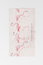 The Flamingo Beach Towel is a light-colored cotton towel featuring pink flamingos and SEWING DOWN SOUTH CHARLESTON, SOUTH CAROLINA printed vertically on the right side—a unique addition to any collection.