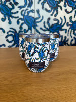 Three Crab Craze Shades of Blue Wine Tumblers with a crab motif sit on wood, against a Sewing Down South pattern that complements the theme.
