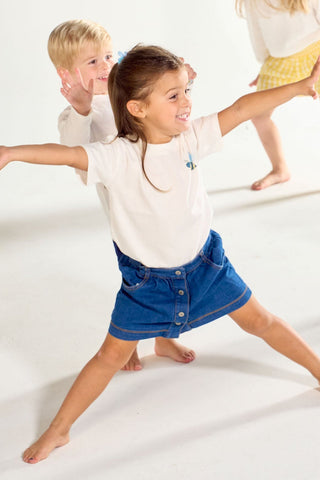 Four children in long and short-sleeved Bee You Short Sleeve Children’s Tee shirts with small bee designs pose in a studio.