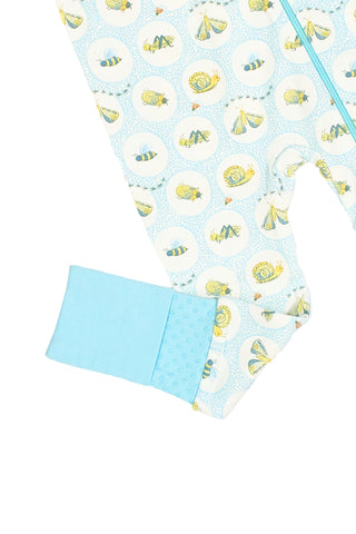 Close-up of a baby romper leg and cuff, showing a blue cuff and white fabric with yellow animal and bee illustrations in dotted circles from the hand-drawn bug print Buggin’ Out Dream & Play Zipper Romper.