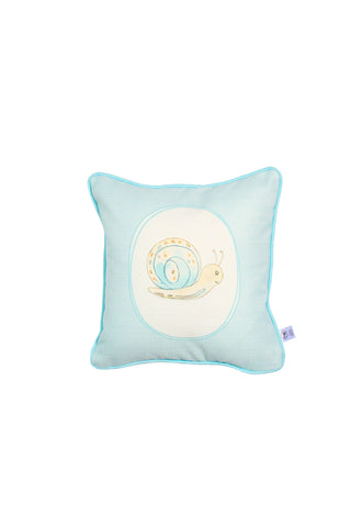 The Buggin’ Out Children’s Pillow is a square, light blue kids’ pillow with a stitched smiling snail in the center, blue piping on the edges, and a small side fabric tag.