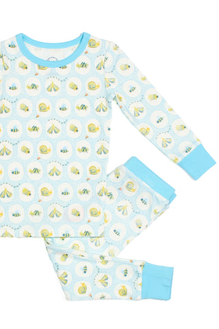 The Buggin’ Out Dream & Play Two Piece Set is a cozy children’s pajama set with light blue cuffs and collar, featuring an outdoor camping print on soft cotton modal fabric—perfect sleepwear for little ones.
