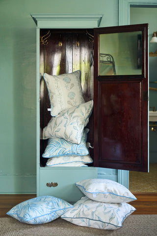 Stacks of pillows in a chest on a green wall