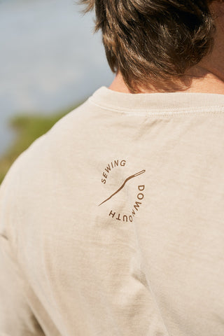 Close-up of the back of The WWWMS Tee, a relaxed fit retro unisex t-shirt in beige with SEWING and DOWN SOUTH printed in a circular design around a curved line.