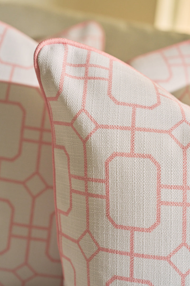 Close-up of two Pink Lattice Pillows, showcasing a blush tone and geometric lattice pattern with pink piping, set against a soft neutral background.