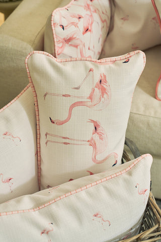 Close-up of the Flamingo Cluster Extended Lumbar Pillow, featuring pink flamingo prints and light pink piping, styled on a beige sofa for a touch of Sewing Down South® pattern and cozy coastal charm.