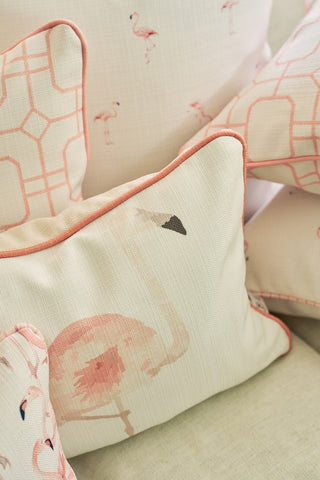 Close-up of decorative throw pillows, including The Flamingo Lumbar Pillow featuring soft pink piping and geometric patterns, arranged on a light sofa for a touch of tropical cheer—an exclusive Sewing Down South design.