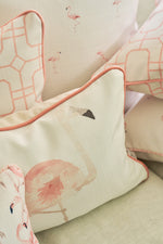 Close-up of decorative throw pillows, including The Flamingo Lumbar Pillow featuring soft pink piping and geometric patterns, arranged on a light sofa for a touch of tropical cheer—an exclusive Sewing Down South design.