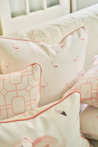 A close-up of three decorative pillows styled on a light sofa, featuring the Flamingo Scatter Oversized Pillow with hand-drawn flamingos, soft pink patterns, and elevated twisted welting for a cozy, inviting look.