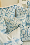 A close-up of decorative pillows with blue geometric patterns, featuring the Blue Lattice Oversized Pillow with a hand-drawn lattice design and coastal bird art, all arranged on a white couch with durable fabric.