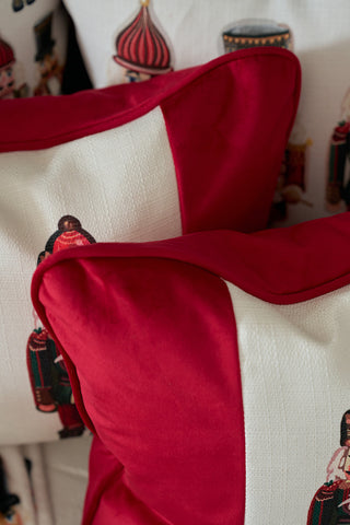 Close-up of Nutcracker Stripe Pillow in Scarlet, featuring vibrant red borders and white fabric with nutcracker soldier designs, stacked to highlight their festive holiday pattern.