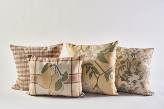 Four decorative pillows, including the Fall Pear Tree Pillow, are side by side. Their plaid and floral designs in beige, green, and peach give a rustic accent—ideal for cozy autumn decor against a white backdrop.
