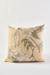 The Fall Pear Tree Pillow is a square beige throw pillow with white flowers and green leaves on thin brown branches, perfect as a rustic accent for autumn decor. Shown here against a plain white background.