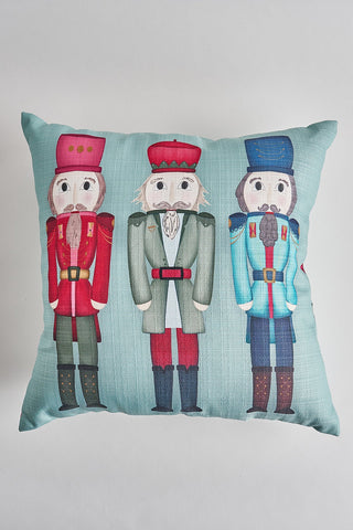 The Festive Nutcracker Pre-Filled Pillow showcases three nutcrackers in red, green, and blue uniforms on a light blue background, adding cheerful seasonal style to your space.