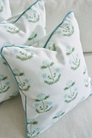 The Bee & Florals Collection: Victorian Floral in Blue pillows, by Sewing Down South, feature a white fabric adorned with green and light blue patterns. Teal piping accents the edges, making them a beautiful addition to any light-colored couch.