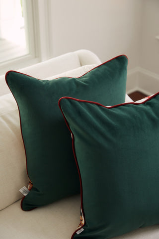 Two Nutcracker Line Up Pillows rest on a cream-colored sofa in a sunlit room, creating a festive holiday look.