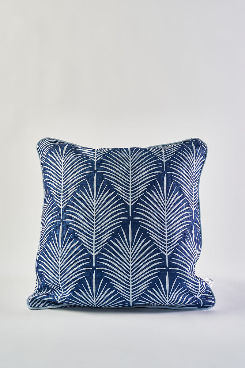 The Oversized Mod Palm Pillow features a navy blue base with a crisp white geometric palm leaf pattern, offering a stylish Southern aesthetic accent to any space. Shown on a plain white background.