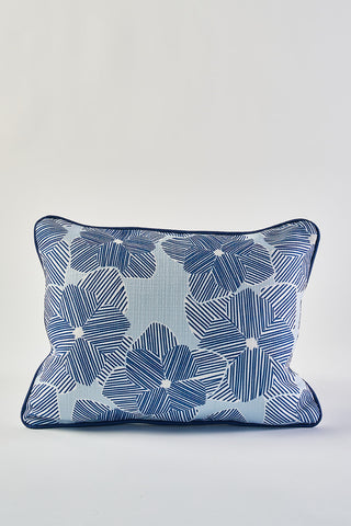 The Mod Flora Lumbar Pillow boasts bold blue striped petals and dark piping on a crisp white background, adding modern Southern flair to any space.
