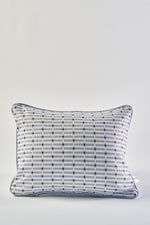 The Mod Mini Crossing Tiles Lumbar Pillow features a white background with a subtle gray grid and small blue dots at each intersection, plus dark piping—perfect for adding Southern style to your space.