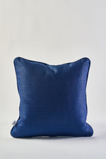 The Mod Geo Diamond in Navy Pillow, featuring a subtle textured pattern and square shape, is shown against a plain white background with a small white tag on its left side.