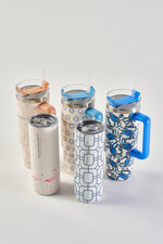Five Crab Craze 30oz Tumblers, each with unique patterns—geometric, blue handles, and pink flamingos—are arranged on a white surface. Made of stainless steel, these insulated cups come with straws and a no-sweat exterior.