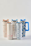 Five Pink Lattice 30oz tumblers with lids and straws stand upright on a white background. Designs feature flamingos, geometric shapes, and blue birds; one has a large blue handle. Each stainless steel cup boasts a no sweat exterior.