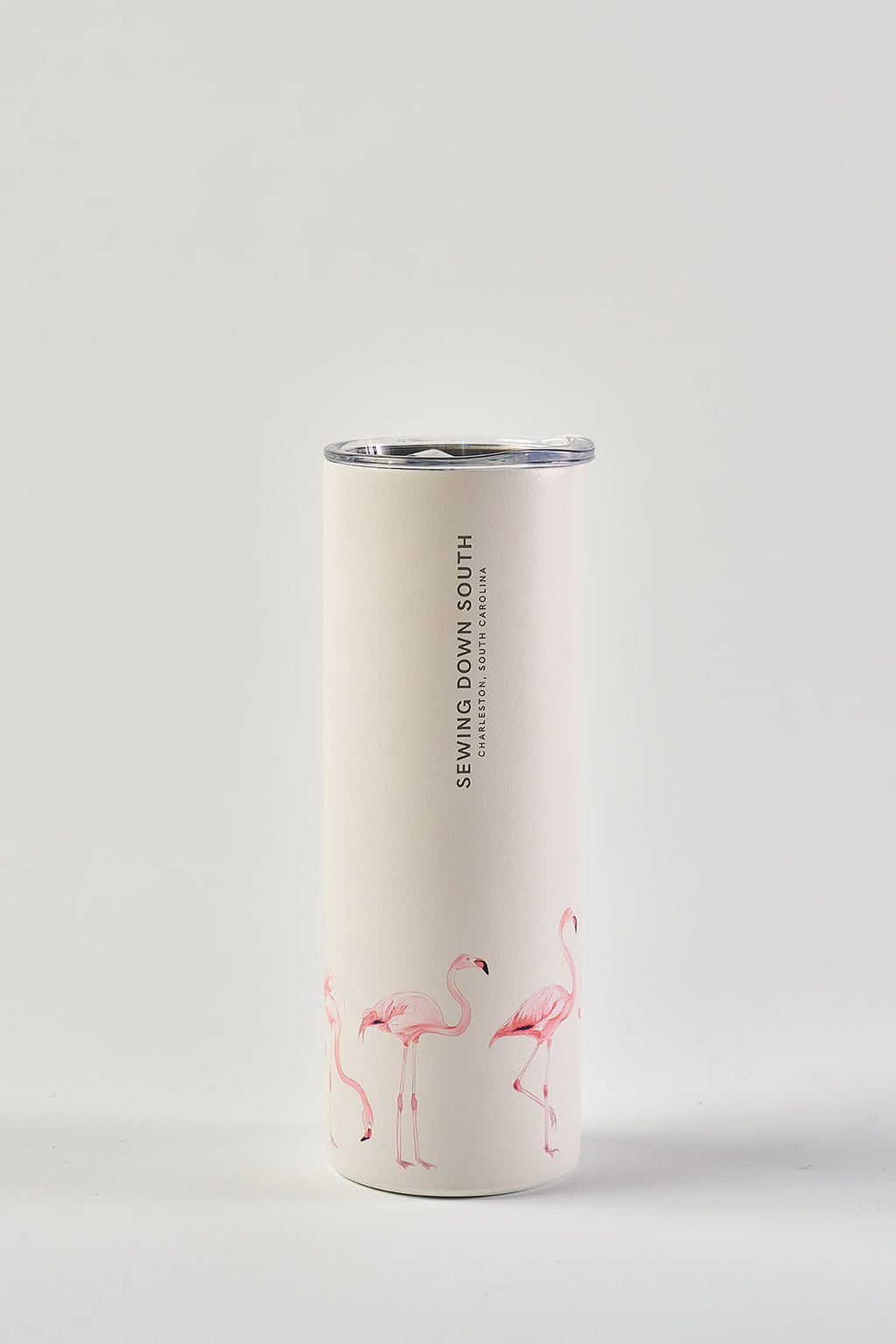 The Flamingo 20oz Tumbler is a white stainless steel tumbler featuring pink flamingos around the base, "SEWING DOWN SOUTH" vertically near the top, a No Sweat Exterior, and a clear plastic lid.