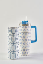 The Blue Lattice 20oz Tumbler is a white stainless steel cup with blue geometric patterns, a light blue lid, Sewing Down South branding, and a no sweat exterior. Tall and slim, it offers style and function.