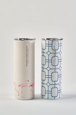 Two tall, cylindrical 20oz tumblers with silver lids and no-sweat exteriors: the left features pink flamingos, the right is the Blue Lattice 20oz Tumbler with a blue geometric pattern. Both display vertical "SIPPING DOWN SOUTH" text.