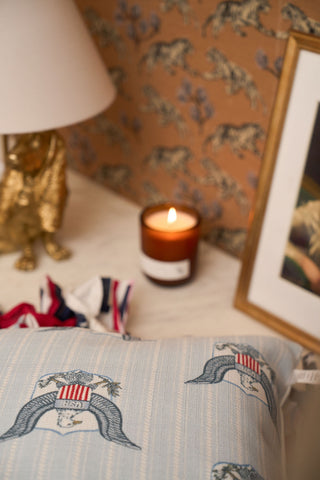 Candle burning with Americana pillow on display