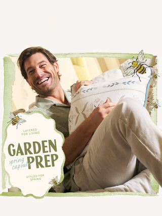 Man lying on a couch, holding a pillow, with 'Garden Prep' text and bee graphics, styled for spring.