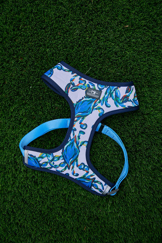 The Crab Craze Dog Harness (S, M or L) from Sewing Down South, featuring a blue, teal, and red abstract pattern, rests on bright green artificial grass.