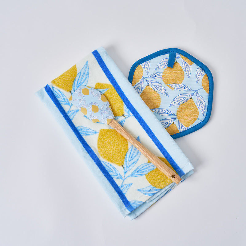 The Lemon Kitchen Bundle includes a 100% cotton towel, pot holder, and spatula—all showcasing matching blue and yellow lemon designs—arranged on a white background.