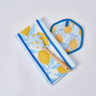 Two folded Lemons in a Line Kitchen Towels (2 pack), a wooden-handled spatula, and a pot holder with yellow lemons and blue leaves pattern are displayed on a white background.