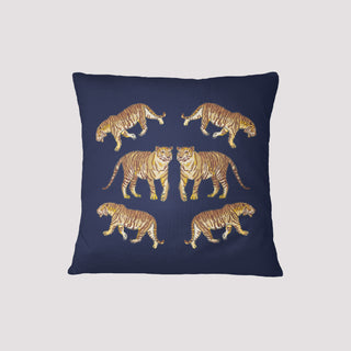 The On The Prowl Midnight Pillow features an exotic navy blue background with a symmetrical pattern of six intricately detailed tiger pairs, all highlighted in golden hues.