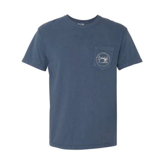 The SDS Vintage Logo Pocket Tee is a heavyweight blue short-sleeved crew neck crafted from cotton, featuring a left chest pocket with a retro-style white logo depicting text and an image of a dog.
