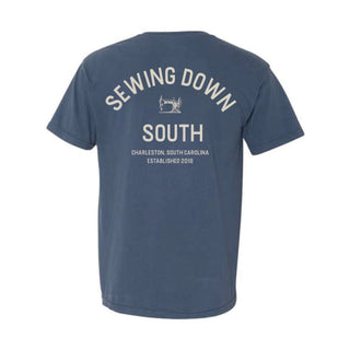 The SDS Vintage Logo Pocket Tee is a heavyweight blue cotton shirt with SEWING DOWN SOUTH and a retro sewing machine graphic on the back. It features Charleston, South Carolina, Established 2018 written underneath.